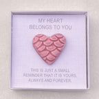 Pink heart-shaped ceramic in a box with sentimental text on a light gray background