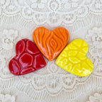 Three colored hearts (red, orange, yellow) on a lace background with text 'Colored Hearts Red Orange Yellow'.